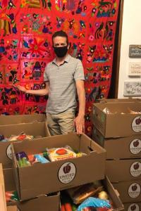 Dr. Organizing a food drive with boxes of food stacked in a room